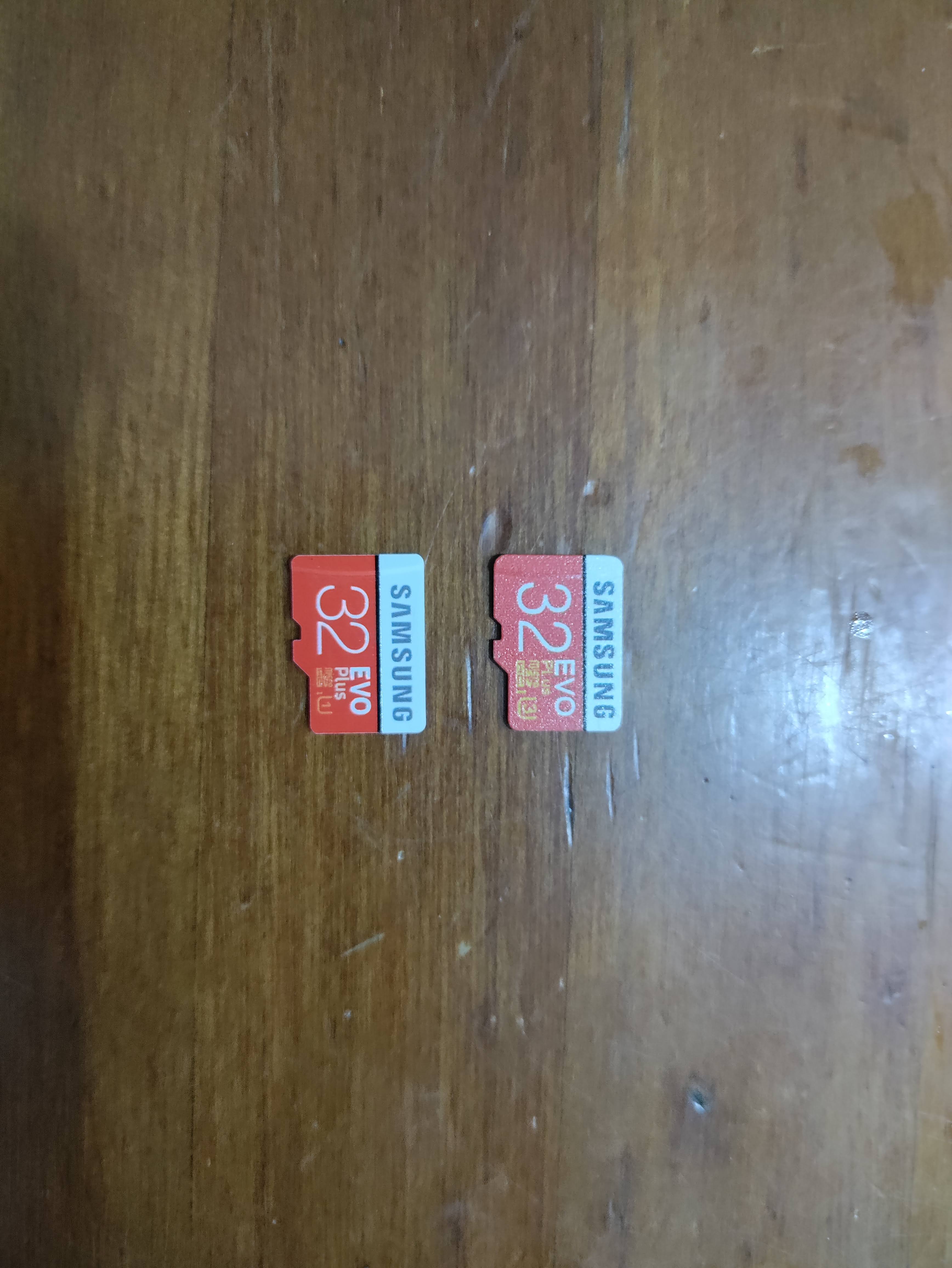 A genuine and fake micro-SD card; the real one is consistent in its text and has a more rougher surface than the fake one.